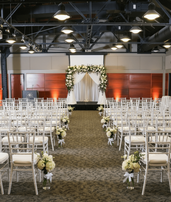Wedding ceremony setup at the Ortiz Center venue in Corpus Christi with white chiavari chairs and floral arch